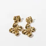 Aros colgantes dorados con forma de flor.