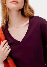 Remera gris de corte clásico, con cuello en V y mangas cortas.