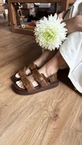 Sandalias marrones de cuero con plataforma forrada en cuero y hebillas ajustables.