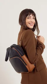 Mochila color beige con doble asa superior y correas traseras regulables. Tiene un bolsillo frontal con cierre y compartimento interno para ipad.