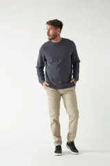 Remera color marrón de manga larga, con bolsillo en el pecho y logo de la marca en etiqueta sobre el bolsillo.