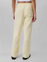 Pantalón de gasa doble color amarillo pálido, de corte recto y cintura elástica con cordones.