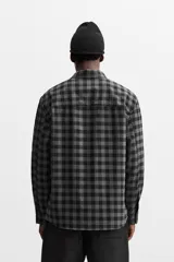 Camisa color crema de corte regular fit, confeccionada en tejido con viscosa. Tiene cuello solapa, manga larga con puños abotonados, bolsillo de parche en el pecho y cierre frontal con botones.