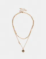 Collar corto dorado de doble cadena, una con círculos pequeños y otra con dije de metal con piedra azul.