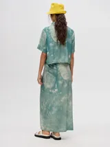 Camisa crop celeste con estampado abstracto, de mangas cortas y cuello clásico.