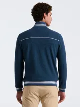 Campera deportiva azul marino de tejido doble con cierre frontal, cuello alto y bolsillos laterales. Presenta rayas blancas en el pecho, hombros y puños, y logo bordado de la marca en el pecho.