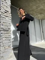 Conjunto negro compuesto por un remerón oversize de mangas largas y un pantalón palazzo de tiro alto con elástico en la cintura.