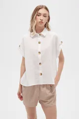 Camisa blanca de algodón con cuello clásico, manga corta con botón y cierre frontal con botones de carey.