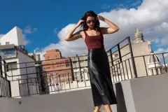 Falda midi de cuero negro, corte evasé.