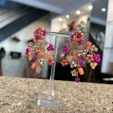 Aros colgantes hechos a mano con cristales rosas, fucsias, corales, plateados y violetas, unidos con alambre dorado.