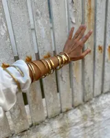 Pulsera tipo esclava abierta, con acabado rústico y textura irregular, en tono plateado. Se vende por unidad.