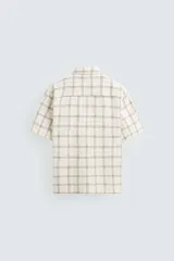 Camisa de manga corta con cuello bowling y corte relaxed fit, confeccionada en tejido con mezcla de algodón y estampado a cuadros.