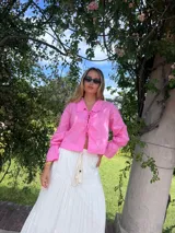 Camisa rosa de lino, de corte crop y mangas largas con puños elásticos.