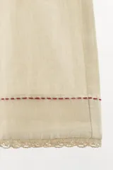 Bermuda color crema confeccionada en hilatura con lino, de tiro alto y cintura elástica. Presenta bolsillos laterales, detalle de hilo a contraste y puntilla combinada a tono en el ruedo.