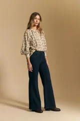 Jean oxford de tiro alto, color azul oscuro, con costuras frontales marcadas y corte acampanado progresivo desde la rodilla.