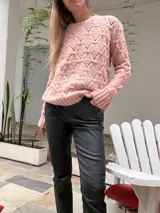 Sweater de punto color rosa con diseño texturizado y mangas largas.