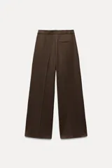 Pantalón ancho gris con textura de espiga, tiro alto, doble cintura elástica ajustable con cordón, pinzas frontales, bolsillos delanteros y falso bolsillo de vivo en la espalda.