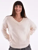 Sweater tejido color crudo, con escote en V y mangas largas.