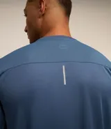 Remera deportiva blanca de poliéster, con cuello redondo, mangas cortas y recortes laterales.