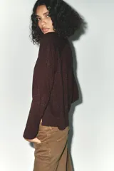 Jersey de punto color marrón con hilo metalizado, cuello redondo y manga larga.