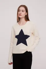 Sweater tejido de color rosa claro con una estrella roja grande en el centro.