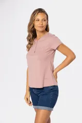 Remera color rosa viejo de corte clásico, con cuello redondo y tapeta con tres botones.