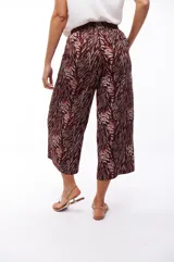 Pantalón capri negro con estampado abstracto en tonos beige, gris y marrón.