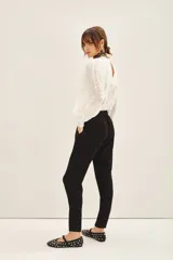 Pantalón babucha azul con elástico en la cintura y cordón de ajuste con terminaciones metálicas. Tiene bolsillos diagonales en el frente y falsos bolsillos ojal en la espalda.