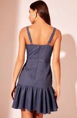 Vestido corto azul de lino con tirantes ajustables, volantes, aberturas caladas, bordado aplicado, cremallera invisible en la espalda y forro interno.