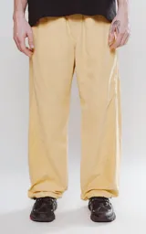 Pantalón de corte sastrero color amarillo claro, de tela suave tipo gamuza, con bolsillos laterales, cintura elástica ajustable y cierre con botón.
