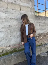 Camisa marrón de tejido de punto en lana con bolsillos de cuero y cierre frontal con botones.