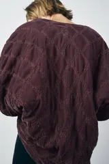 Kimono abierto color borgoña de terciopelo acolchado con pespuntes a tono y bolsillos de parche.
