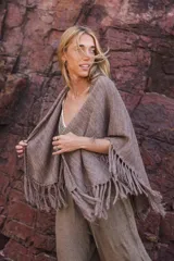 Capa tejida color negro, con flecos largos en los bordes.