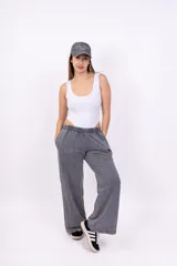 Pantalón deportivo gris con efecto lavado, corte ancho, cintura elástica y logo bordado en negro.