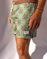 Short de baño verde con estampado de figuras geométricas en marrón y beige, cintura elastizada con cordón ajustable.