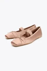 Zapato bailarina color rosa viejo, de efecto satinado, con punta cuadrada, tira elástica y lazo decorativo en la parte delantera.