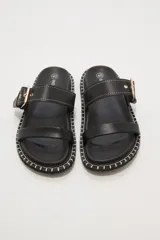 Sandalias negras de cuero sintético con doble tira y hebilla dorada ajustable.