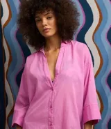 Camisa de playa color rosado, de voile de algodón, con escote en V, mangas 3/4, abotonada adelante y pliegue en la espalda.