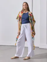 Kimono tejido con estampado abstracto multicolor, mangas amplias estilo japonés y terminación de ruedo con borlas amarillas.