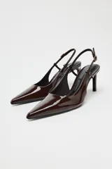 Zapato de tacón destalonado color marrón charol, con punta fina y tira trasera con hebilla.