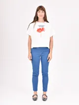 Remera blanca de corte recto con estampado de flores rojas y texto azul "PROFUMO DI FIORI".