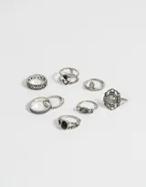 Set de 8 anillos plateados con detalles en bajo relieve y apliques símil piedra.