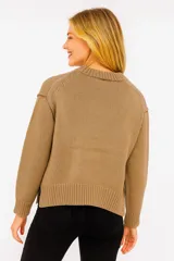 Sweater de punto color beige oscuro, con cuello redondo y mangas largas. Diseño holgado y tejido acanalado.