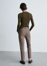 Pantalón crop gris de corte skinny, con tiro medio, trabillas, cierre de cremallera y gancho, dos bolsillos laterales y forro interior.