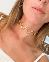 Choker rígido de metal dorado con diseño ondulado o serpenteante.
