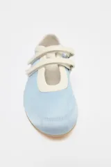 Zapato tipo bailarina deportiva color celeste con efecto satinado, puntera redondeada, suela plana y doble tira con ajuste adhesivo.
