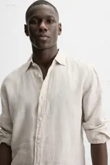 Camisa celeste de lino, de corte recto, manga larga y cuello clásico.