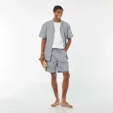 Short de lino azul con rayas verticales blancas, cintura elastizada con cordón ajustable y bolsillos laterales.