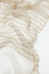 Pashmina rectangular de tejido ligero color beige con rayas horizontales color arena y flecos cortos en los extremos.