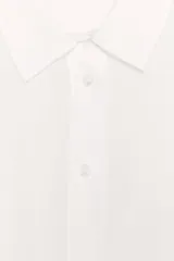 Camisa marrón de corte recto, con cuello solapa, manga corta y cierre frontal con botones.
